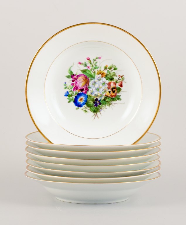 Bing & Grøndahl, otte dybe tallerkner i porcelæn håndmalet med polykrome 
blomster og gulddekoration.