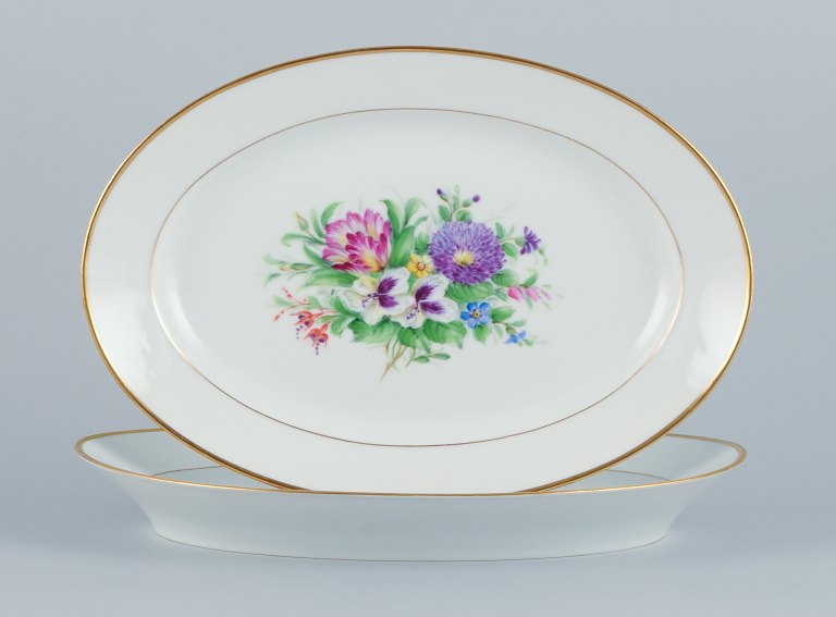 Bing & Grøndahl, two large oval platters hand-painted with polychrome flower 
motifs and gold trim.
