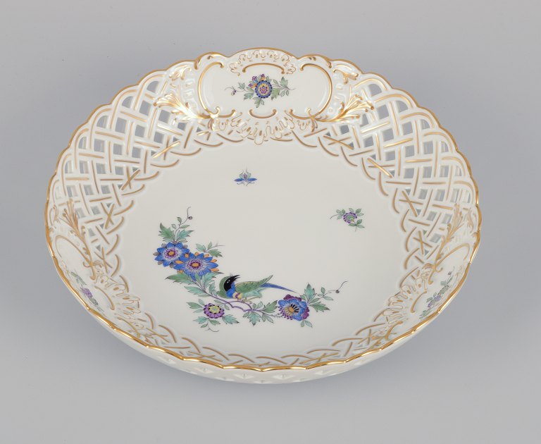 Meissen, Germany. Open lace bowl in porcelain, decorated in gold with an exotic 
bird on a flower branch. Hand-painted.