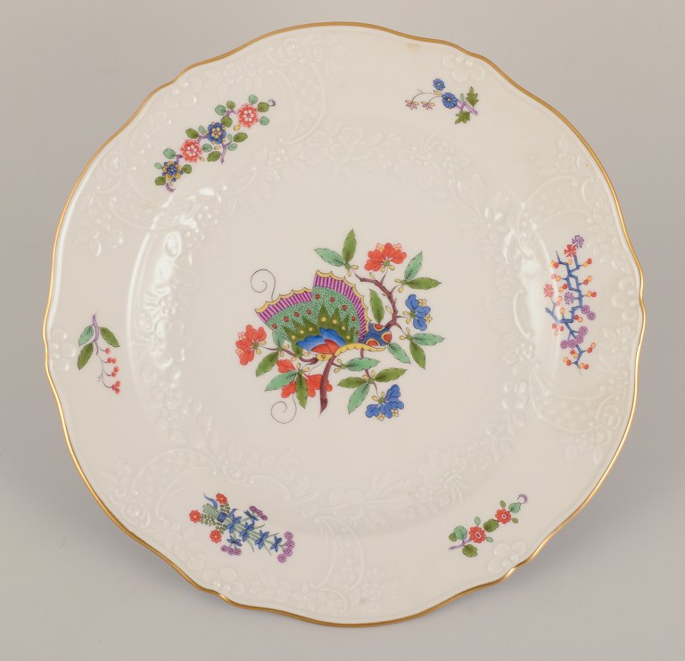 Meissen, Germany. Hand-painted dinner plate featuring a butterfly on a branch 
and polychrome flower motifs. Gold rim.