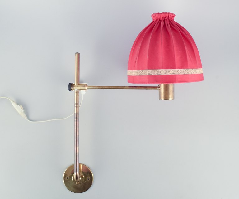 Hans Agne Jakobsson, Swedish designer. Wall lamp in brass with a lampshade in 
red fabric. Modernist design.