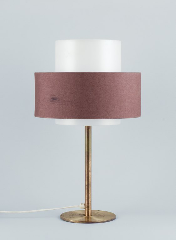 Luxus, Sweden. Large table lamp in brass with a shade in plastic and brown 
fabric.