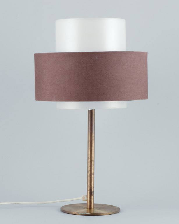Luxus, Sweden. Large table lamp in brass with a shade in plastic and brown 
fabric.