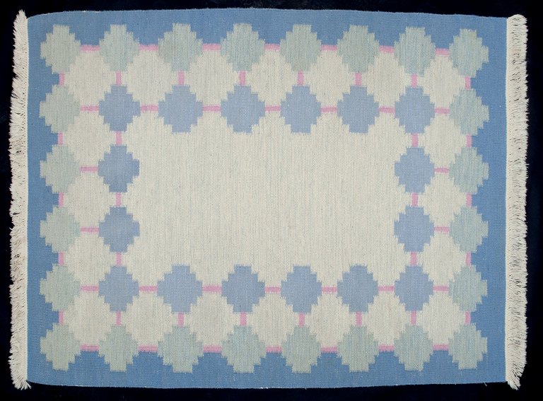 Swedish textile artist. Handwoven wool carpet in Rölakan technique. Modernist 
design. Blue and pink colors in a geometric pattern.