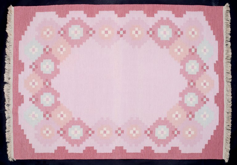 Swedish textile artist. Large handwoven wool carpet in Rölakan technique. 
Modernist design. Pink, red, and blue colors in a geometric pattern.