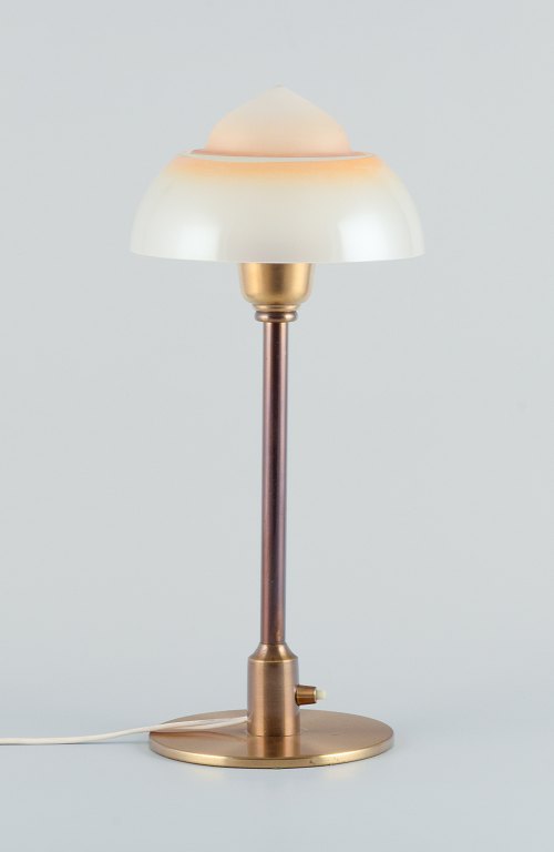 Fog & Mørup. Table lamp with a stem in patinated brass, fitted with a "Spejlæg" 
(Fried Egg) glass shade.