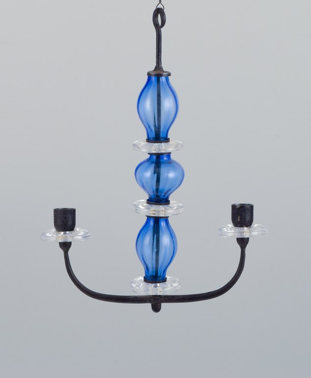 Erik Höglund (1932-1998) for Kosta Boda, Sweden. Rare two-armed hanging candle 
holder in cast iron and mouth-blown art glass.
