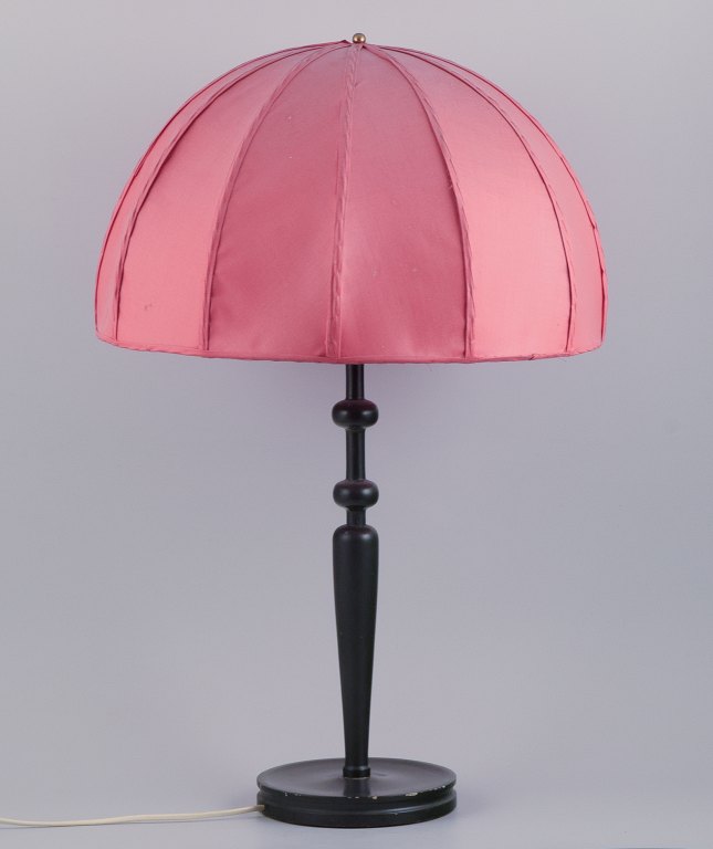 Josef Frank (1885-1967) for Svenskt Tenn, Sweden. Large Art Deco table lamp with 
a dark pink fabric shade and a black wooden base.