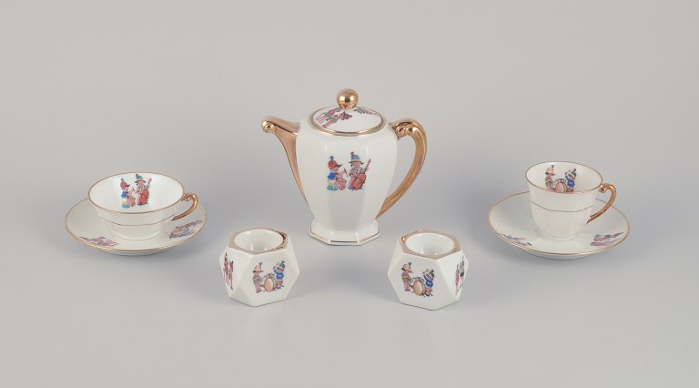 Limoges Porcelaine, Frankrig. 
Kaffekande, tekop og en kaffekop med underkopper samt to æggebægre i porcelæn. 
Motiver af børnemusikanter.