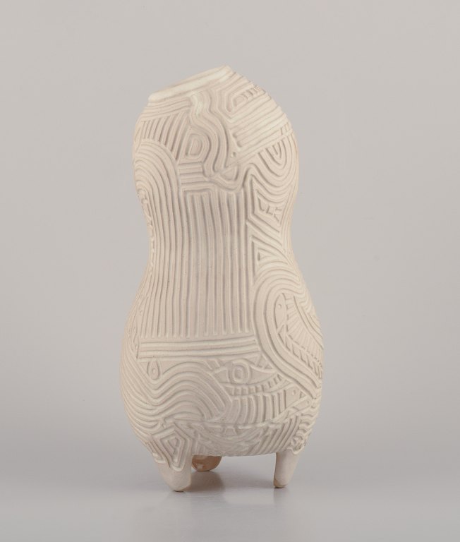 Christina Muff, Contemporary Danish ceramic artist (born 1971).
Unique handbuilt tall stoneware vessel. The vessel is covered in a cream glaze. 
The vase has symbolic carvings of eyes, fish etc.