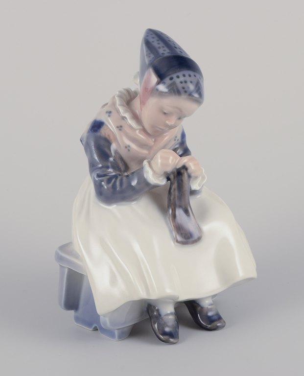 Royal Copenhagen porcelain figurine.
Amager girl in traditional dress with knitwear.