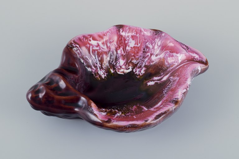 Vallauris, France, snail-shaped stoneware bowl with glaze in shades of pink and 
brown.