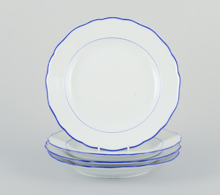 Meissen, Germany. A set of four dinner plates.
White porcelain with blue rim.