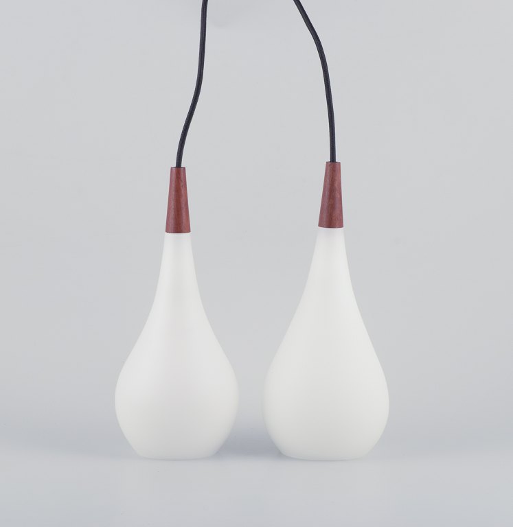 A pair of Louis Poulsen pendants in opal glass and precious wood.