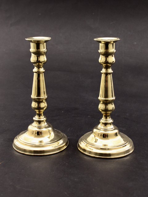 A pair of brass candlesticks on a round base