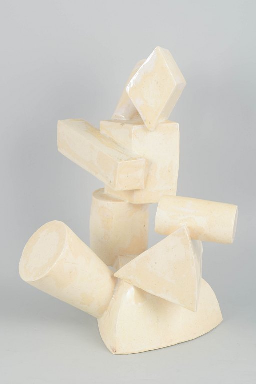 Christina Muff, Contemporary Danish ceramic artist (born 1971).Monumental sculpture, cubistic style. The stoneware surface is covered in a glossy Cream coloured glaze.Measurements : 41 x 32 cm.Dating: 2025Perfect condition. Signed.Christina Muff handcrafts her clay sculptures using techniques such as slab building and coiling. Large surfaces of clay are slowly shaped into detailed sculptures with complex, naturalistic forms. It is a time-consuming process, as the sculptures—due to their size—require a long drying period before being fired, often multiple times, to achieve the desired texture and color. During the glazing process, she uses a variety of techniques in combination with natural materials such as sand, chalk, and locally dug clay from Denmark. The goal is to create textures and surfaces that resemble man-made objects reclaimed by nature.Christina Muff, contemporary ceramicist (b. 1971), studied Design at the Margrethe School in Copenhagen in the 1990s and later at the TEKO Center in Herning. Throughout her career, Christina has worked with a range of media including visual art, textiles, graphics, and fine metal jewelry. After achieving commercial success with jewelry and graphic design (Kortkartellet), she now considers clay her primary medium. As an independent artist, Christina has lived and worked in various countries, including the USA, Saudi Arabia, and several places in Europe. She is now based in Copenhagen, where she has established her ceramic studio.Her work is collected by private clients in Australia, Asia, USA, Denmark and in the UK.