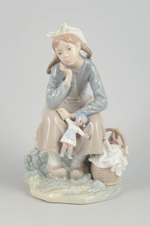 Lladró figurine, seated girl with doll.