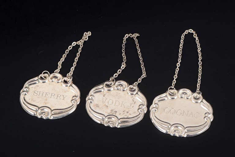 Three silver decanter labels.