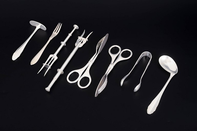 Collection of eight silver-plated serving utensils.