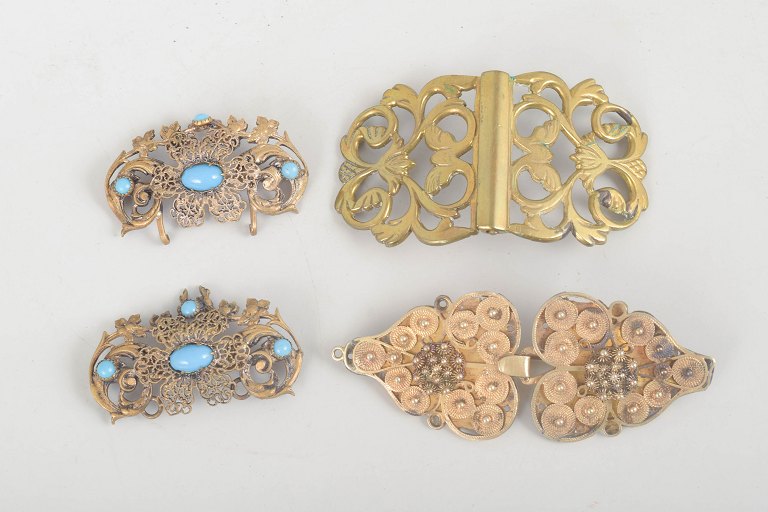 Set of three belt buckles and one brooch.